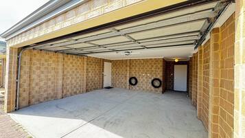 A garage with a concrete floor, brick walls, and a metal garage door.