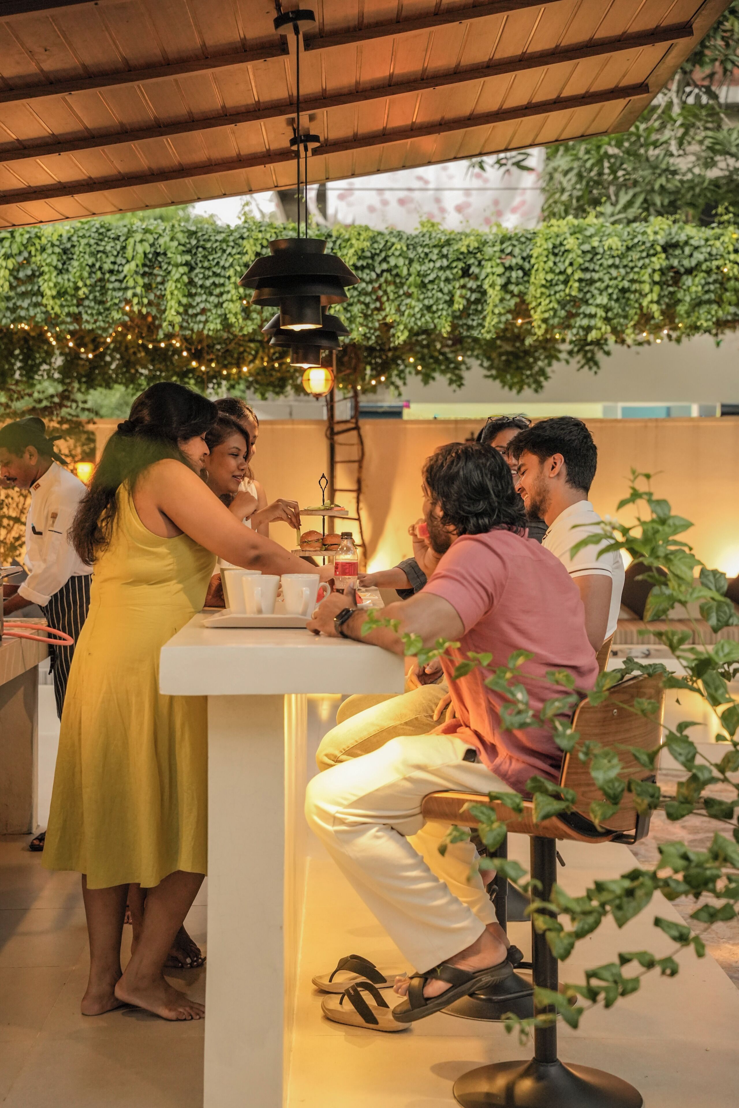Un grupo de personas sentadas alrededor de una mesa con mantel blanco, conversando.