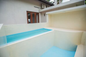 Una piscina con forma rectangular y el interior azul claro.