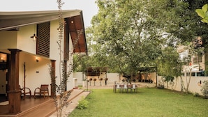 A modern house with a patio, outdoor seating, and a well-maintained lawn.