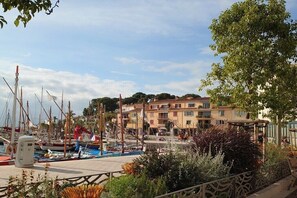 A marina with boats docked, a building with balconies, and a clear sky. - Holiday apartment with 2 bedrooms (Sanary)