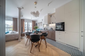 Eine moderne Küche mit Essbereich, einer Couch und Blick ins Freie.