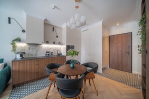 Eine moderne Küche mit Essbereich, Holzschränken und einem schwarzen Stuhl mit Holzfuß.