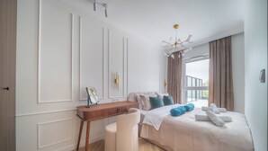 Un dormitorio con cama, mesita de noche, silla y vistas al exterior.