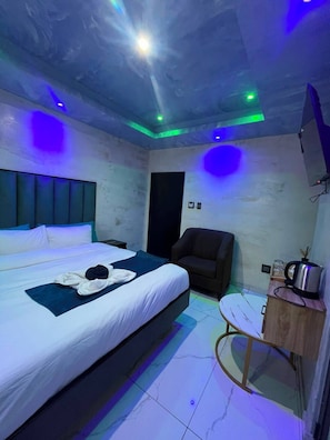 A hotel room with a bed, a chair, a desk, and a television. - Meriambase lodge (Johannesburg)