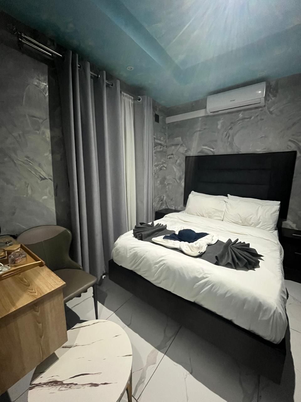 A hotel room with a bed, a desk, and a chair.