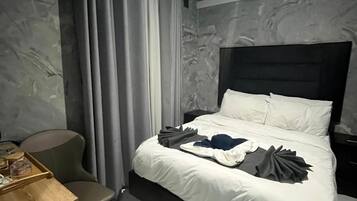 A hotel room with a bed, a desk, and a chair.