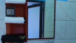 Un baño con un lavabo blanco, un espejo y un perchero para toallas.