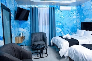 A hotel room with a bed, a chair, a small table, and a TV. - Meriambase lodge (Johannesburg)
