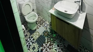 Un baño con inodoro, lavamanos y espejo.