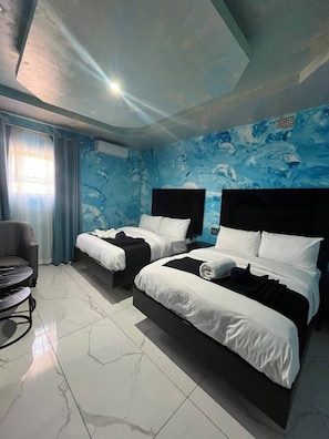 A hotel room with two beds, a chair, and a small table. - Meriambase lodge (Johannesburg)