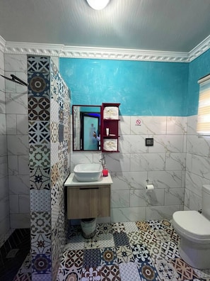 A bathroom with a white sink, a mirror, a red cabinet, and a patterned floor. - Meriambase lodge (Johannesburg)