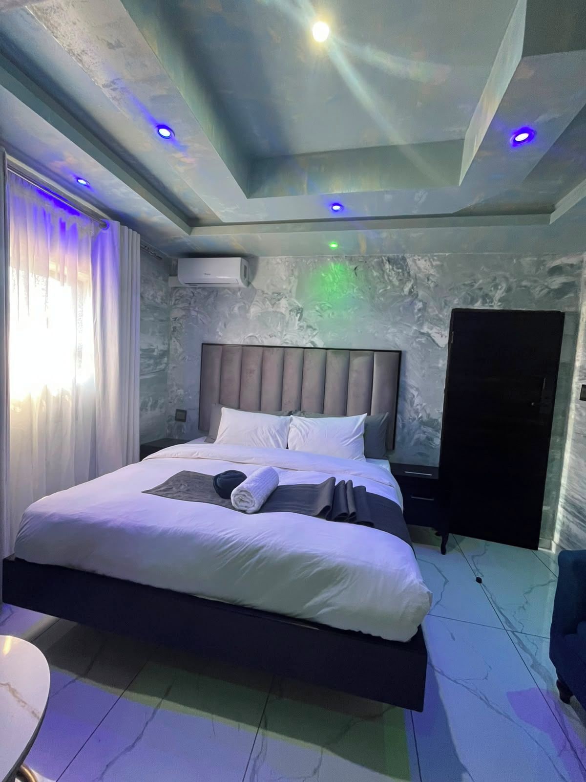Een moderne slaapkamer met een bed, nachtkastjes en een kledingkast.