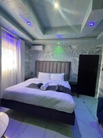 Una camera da letto moderna con un letto, comodini e un armadio.
