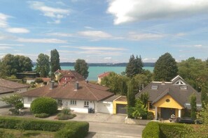 Ein Wohngebiet mit Häusern, blauem Himmel und einem Wasserkörper im Hintergrund.
