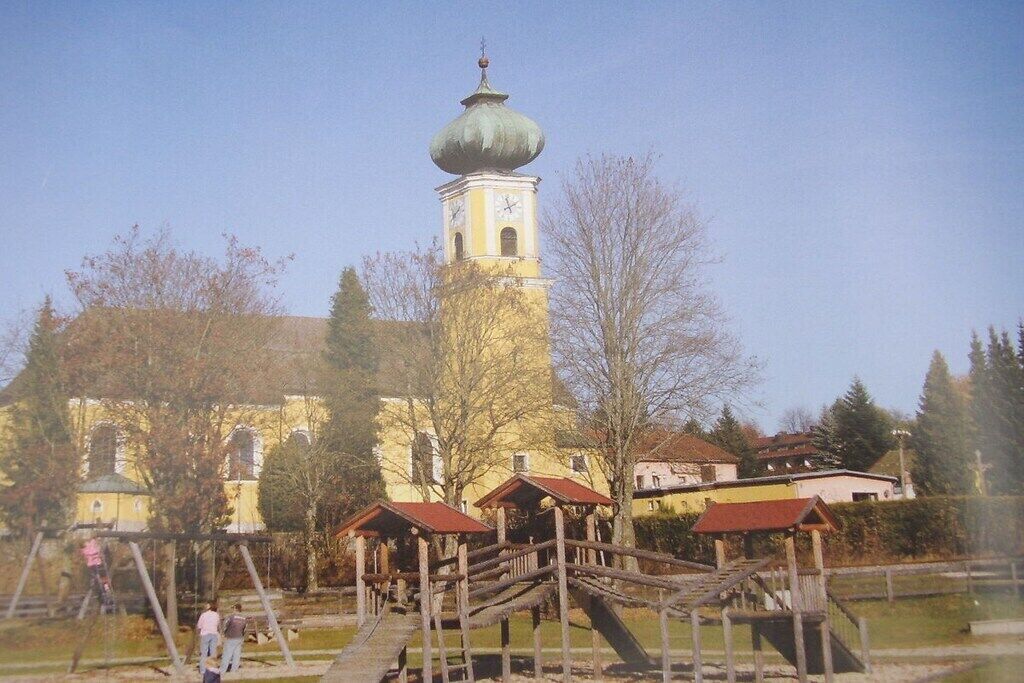 A historic building with a prominent tower and a wooden bridge.