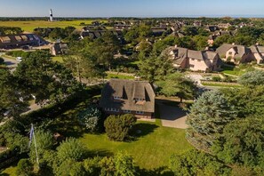 Un quartier résidentiel avec des maisons, un phare et un mât de drapeau.