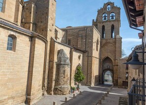 Un edificio storico con un'imponente torre campanaria e portali ad arco.