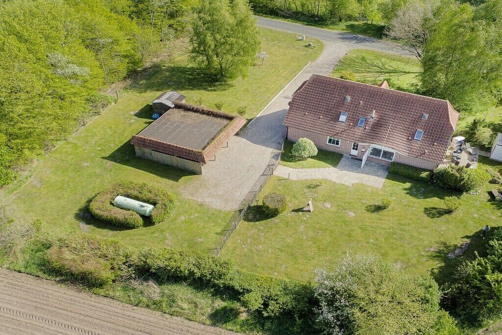 Il s’agit d’une propriété résidentielle comprenant une grande maison, un garage séparé et une pelouse bien entretenue.