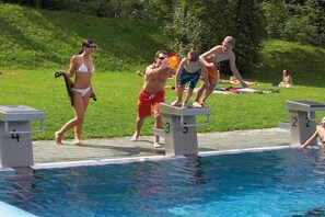 Ein Schwimmbecken mit Sprungtürmen und nummerierten Bahnen.