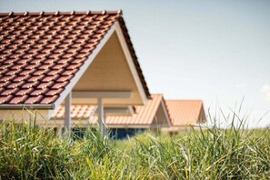 A building with a tiled roof and a triangular facade. - "Skipper House" Type A plus (Neustadt\/Holstein - OT Pelzerhaken)