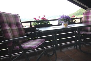 A balcony with two chairs and a table, overlooking a scenic view. - Holiday apartment with 2 bedrooms (Oberstaufen)