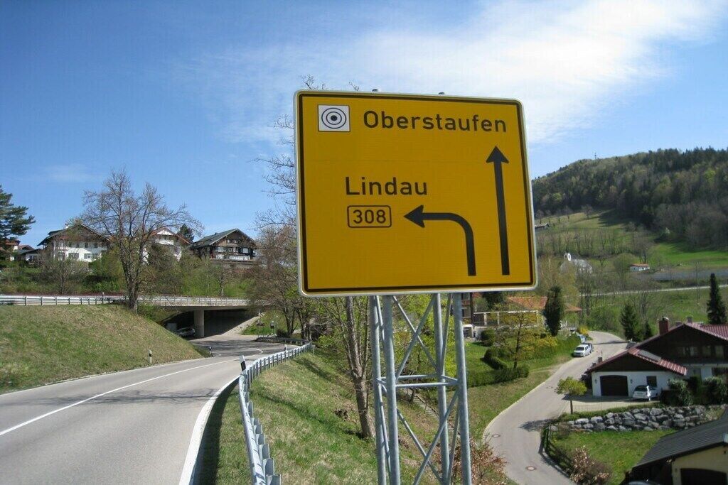 Trafikskilt med pile og bynavnet 'Lindau' samt nummeret '308'.
