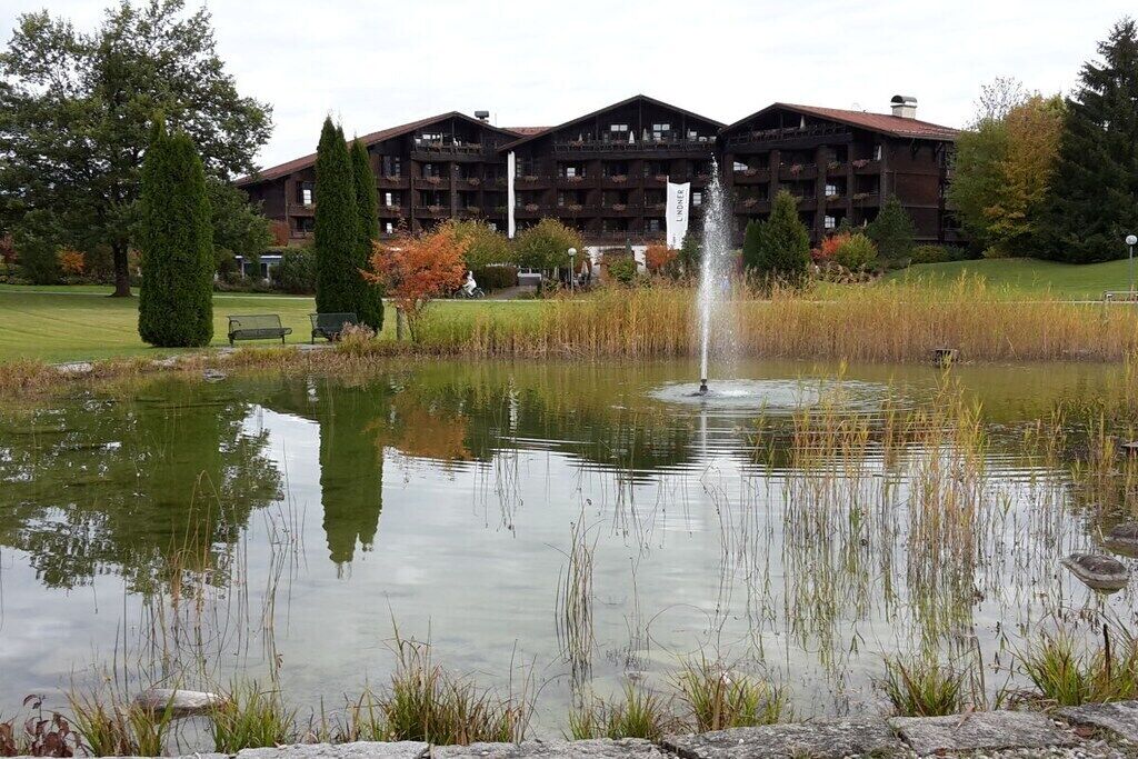 Un bâtiment doté de nombreux balcons et un bassin avec une fontaine.