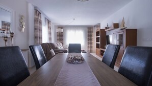 Ein Essbereich mit einem langen Tisch, Stühlen und einer dekorativen Tischmitte.