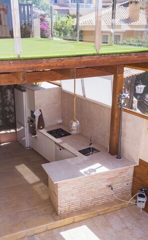 A modern kitchen with a built-in stove, sink, and hanging light fixture.