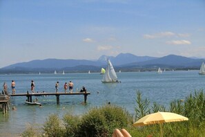 A lake with people on a dock, sailboats, and mountains in the background. - Mayrhof - Panoramic View (Eggstätt)