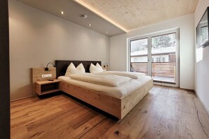 Een moderne slaapkamer met een houten bed, een nachtkastje en een groot raam.