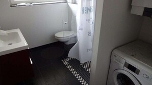 Un bagno piccolo ma funzionale, con il water, il lavandino e una lavatrice.