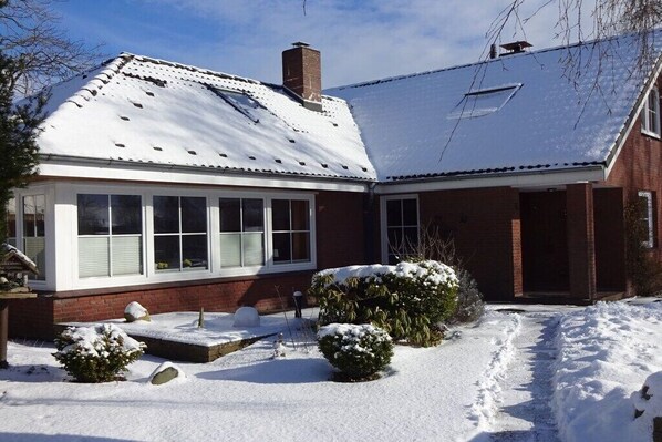 A two-story house with a snow-covered roof and a brick exterior. - Holiday apartment in Sarkwitz with parking (Sarkwitz)