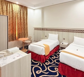 Habitación de hotel con dos camas, un escritorio, una silla y baño.