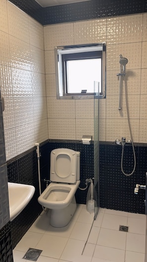 A bathroom with a toilet, bidet, and shower. - Outad United Hotel 2 (Makkah)