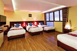 A hotel room with four beds, wooden flooring, and large windows with curtains. - Sapa Casa Bella Homestay (Sa Pa)