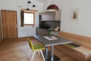 Eine moderne Küche mit Essbereich, Holzboden und einer Bank.