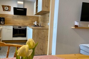 A modern kitchen with a wooden countertop, built-in oven, and a coffee machine. - Holiday apartment with 2 bedrooms (Füssen)