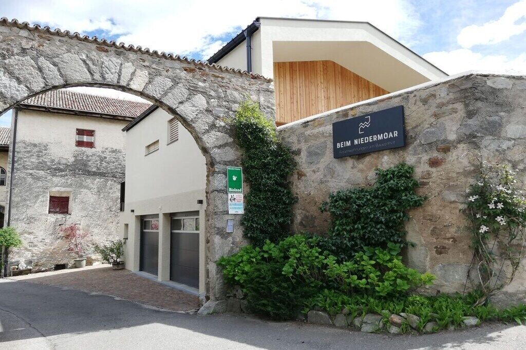 Un arco de piedra que conduce a un edificio con la inscripción 'BEIM NIEDERMOAR'.
