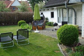 A patio with outdoor furniture, a grill, and a hedge. - "Witt Hus" Home office and vacation (St-Peter Ording (Böhl))