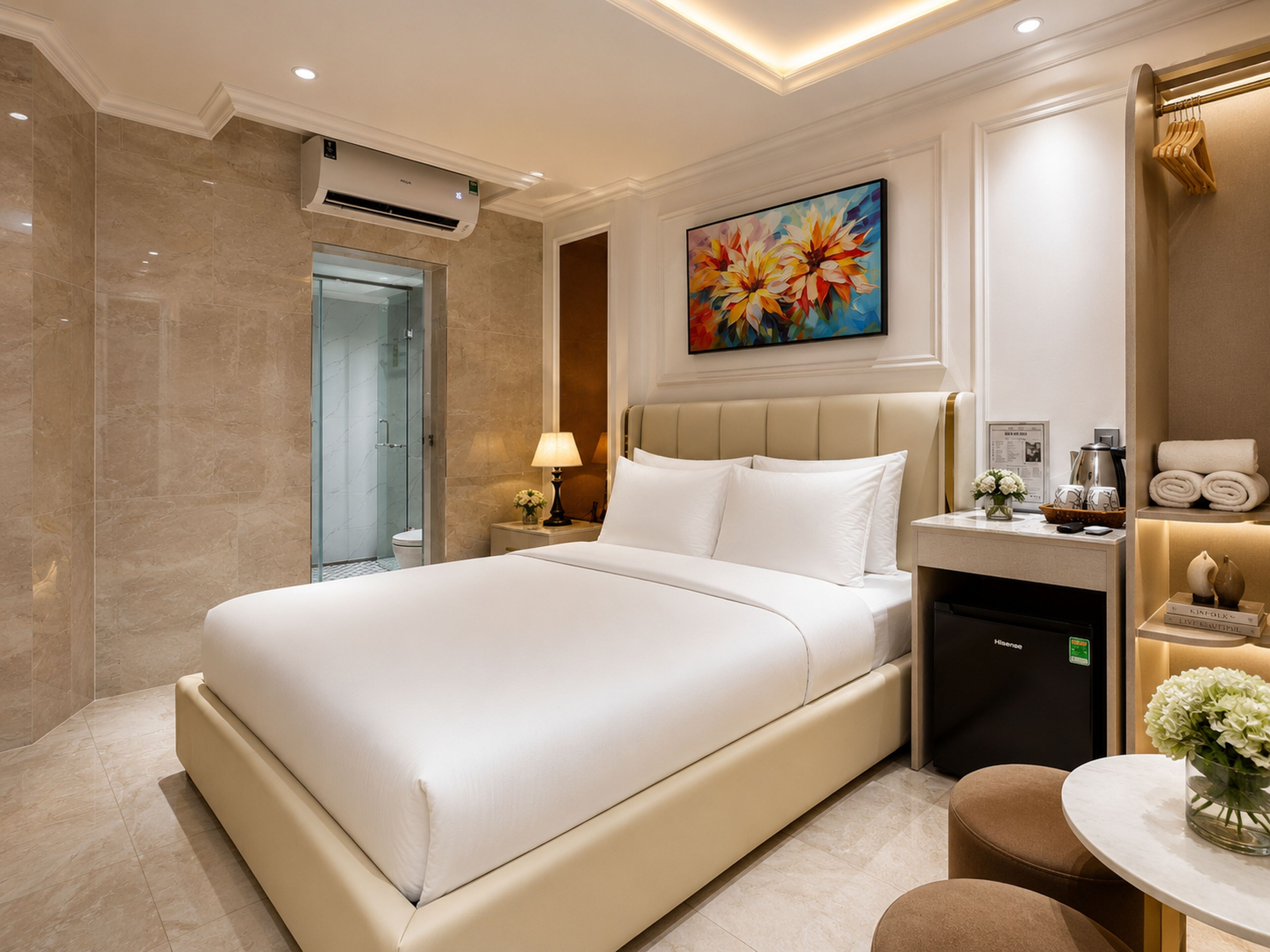 Quarto de hotel moderno com uma cama grande, uma escrivaninha, uma cadeira, um chuveiro e um quadro na parede.