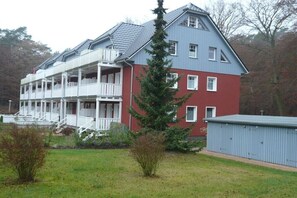Ein zweistöckiges Gebäude mit Balkon und rotem und blauem Anstrich.