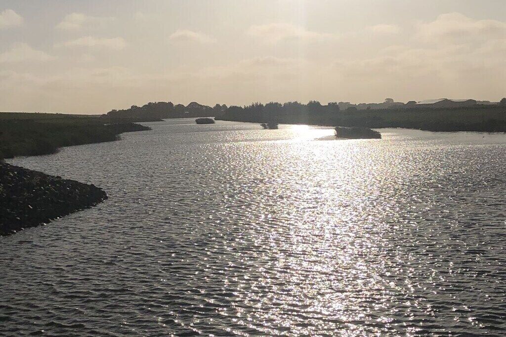 A river with boats and a distant shoreline.