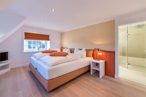 Een moderne slaapkamer met een groot bed, een nachtkastje, een televisie en een douchecabine van glas.