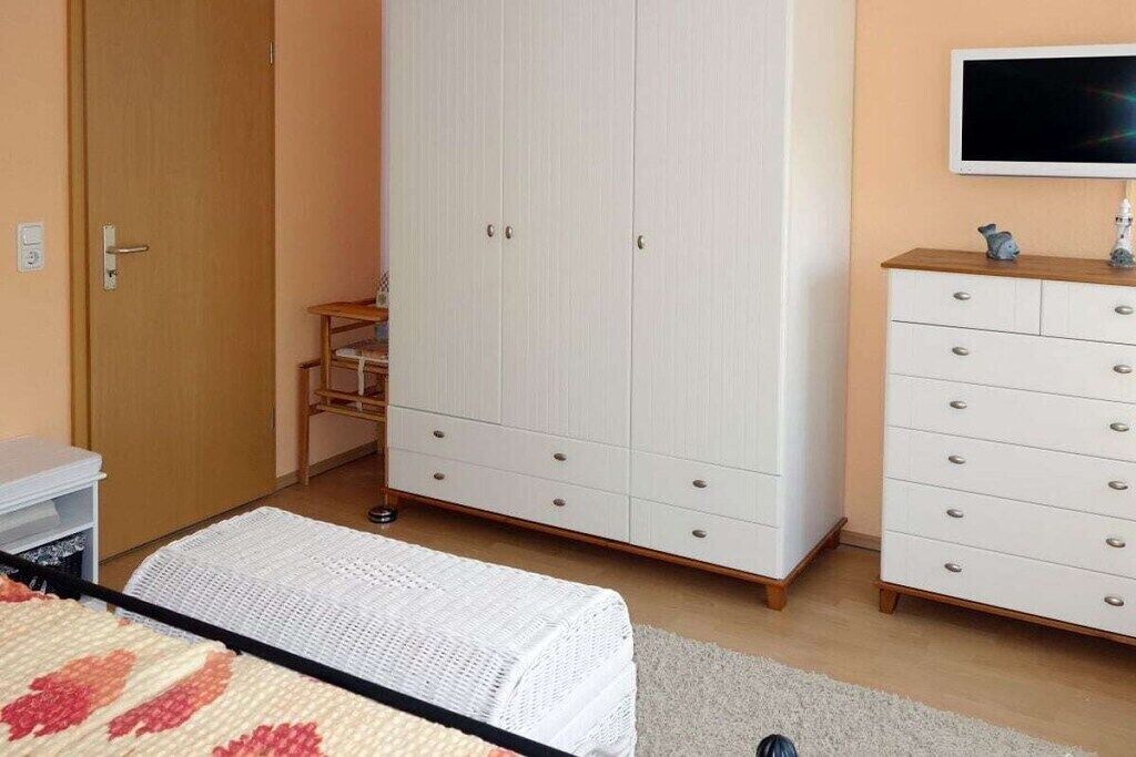 Ein Schlafzimmer mit Bett, Kleiderschrank, Schminktisch und Fernseher.