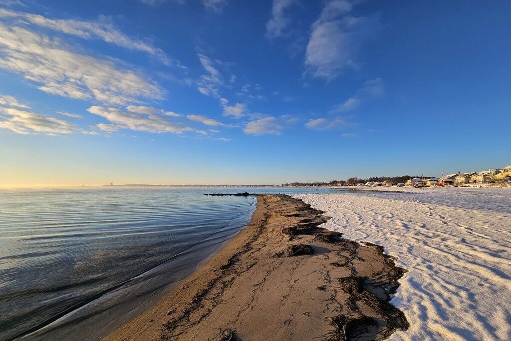 A beach with a clear sky and calm water.