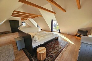 A bedroom with a large bed, a television, and a view of the outdoors. - Holiday home with 2 bedrooms (Sierksdorf)