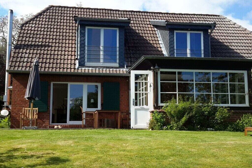 A two-story house with a tiled roof, a front door, and a visible window.