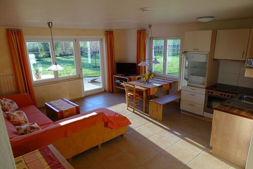Ein kompakter Wohnbereich mit Sofa, Esstisch und Küchenzeile.